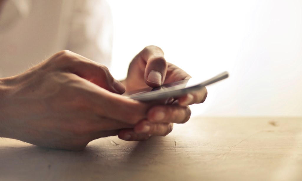 hands typing on mobile phone