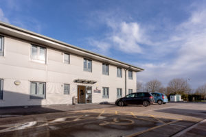 External view of Somerset Enterprise Centre Highbridge. It's a two storey building with allocated parking outside including a disabled space.