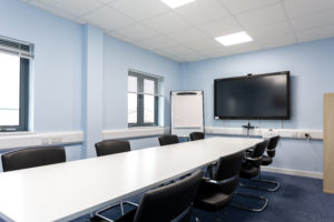 Highbridge meeting room with space for 8 people, a tv mounted on the wall and a floor standing white board