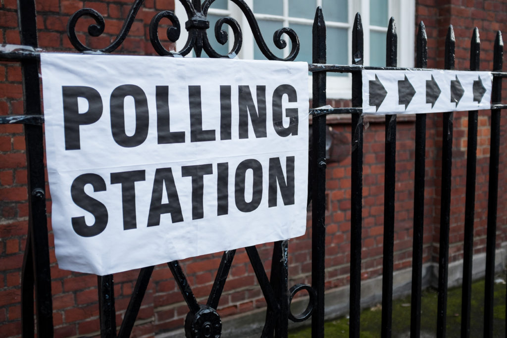 Sign attached to a fence showing polling station