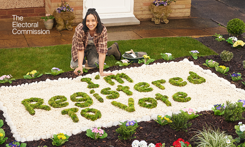 Woman in garden with plants spelling out 