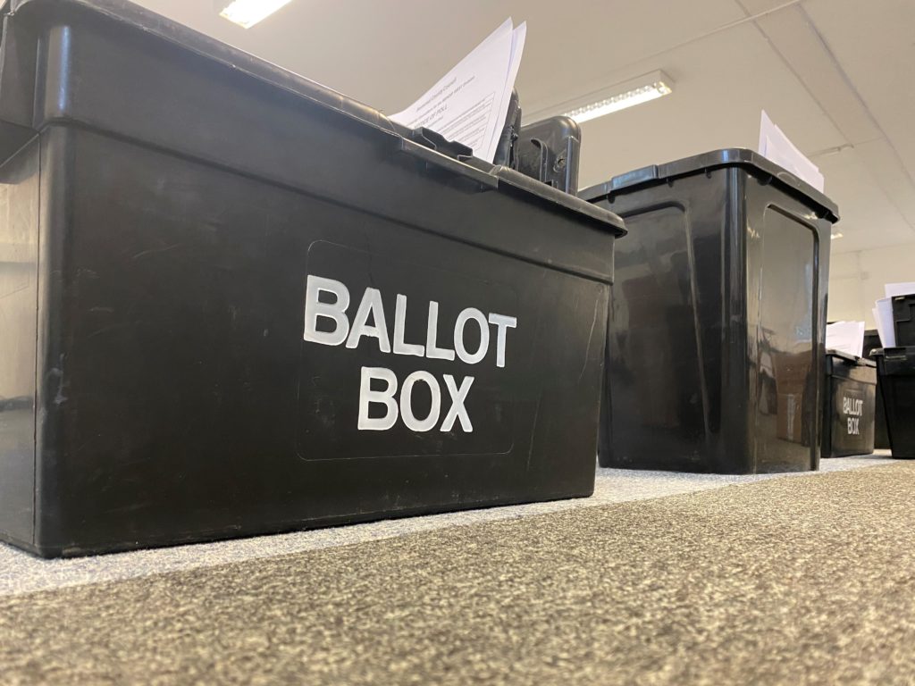 Black ballot boxes lined up in a row.