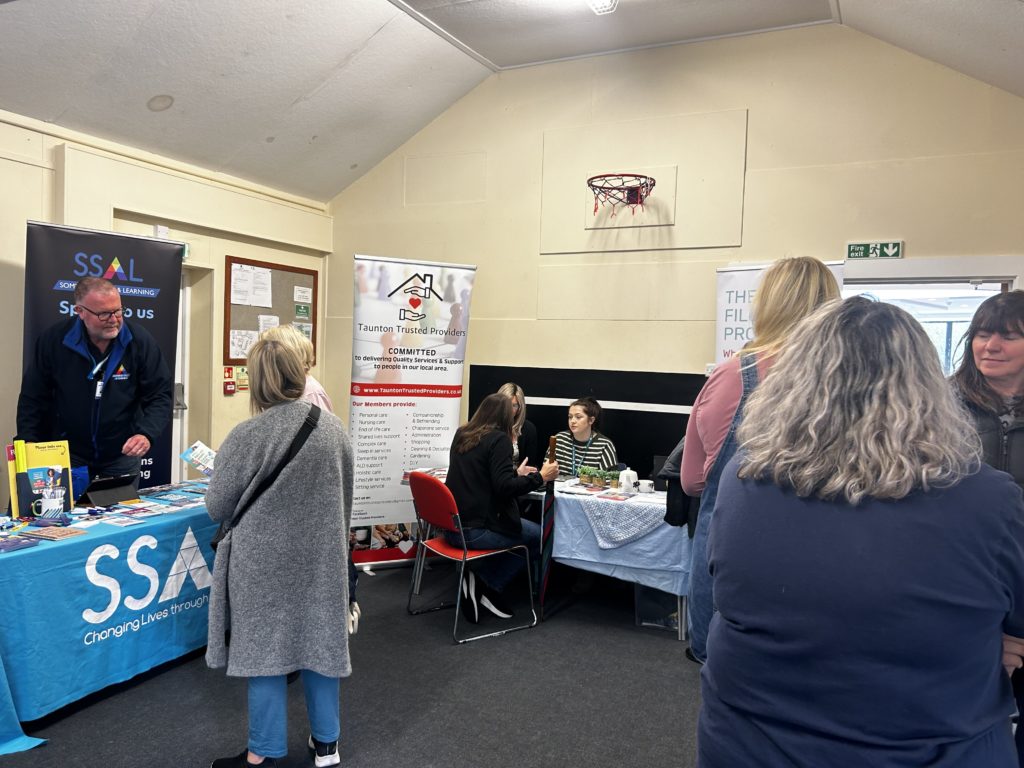 People standing around information stalls and talking to each other.