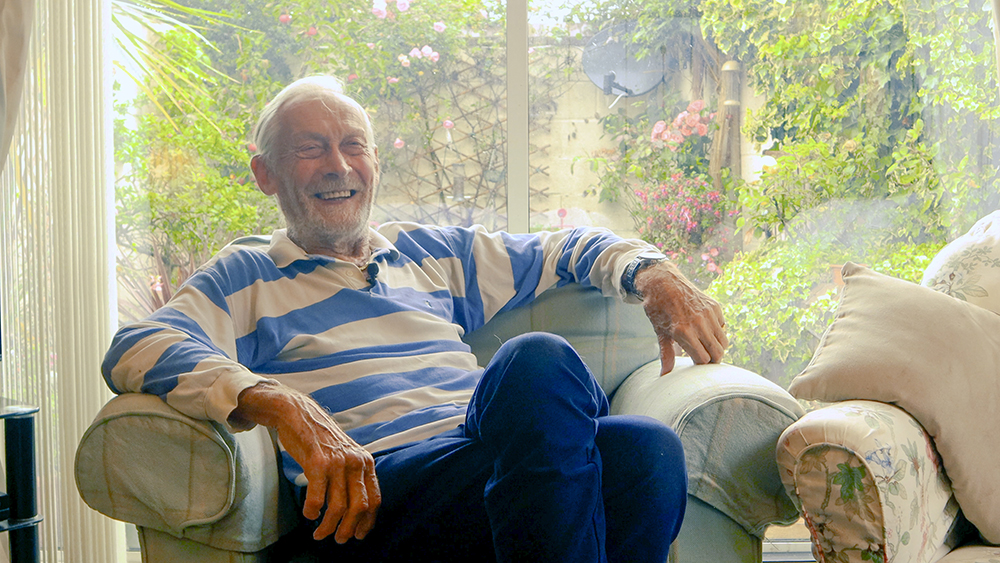 RAF Veteran and Foster Carer, Nigel, smiling whilst sitting in his armchair.