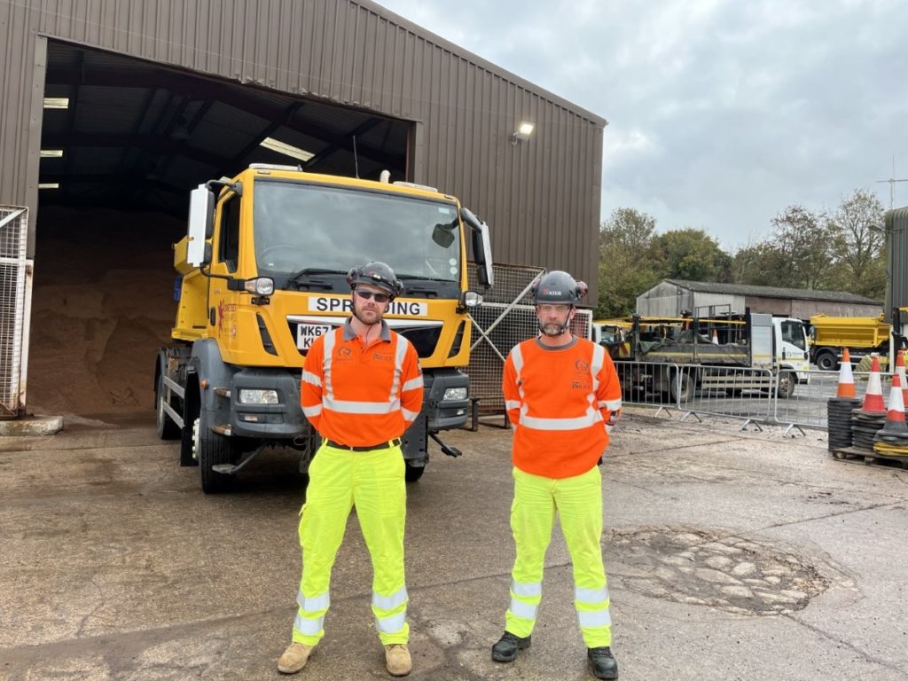 2 members of the council's road gritting team stood in from of a gritter lorry