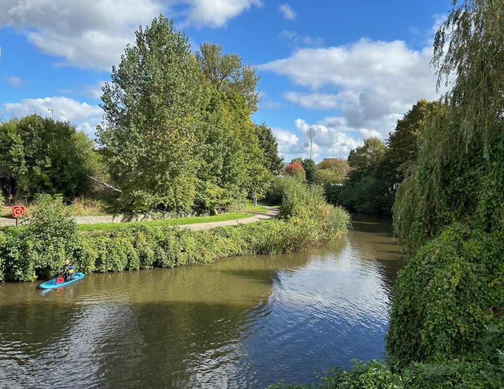 A beautiful sunny day view of the river Tone near Taunton, with flourishing trees on the bankside.