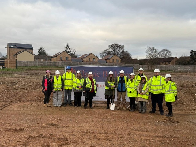 Cllr Federica Smith Roberts holding a spade ahead of the groundbreaking ceremony to mark the start of the next phases of the Woolaway project. Federica is joined from Somerset Council officers and representatives from contractors Classic Builders.