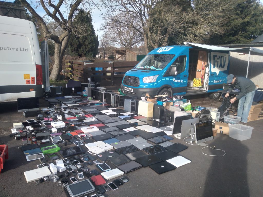 Donated tech laid out in rows in front of the Fixy van.