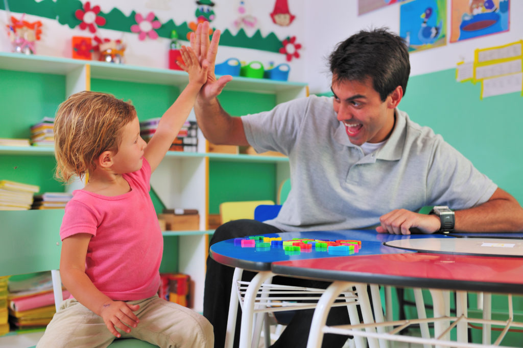 Social worker and child giving a high-five